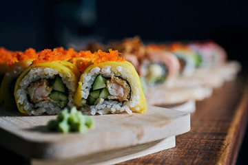 Various kinds of sushi served on wooden table