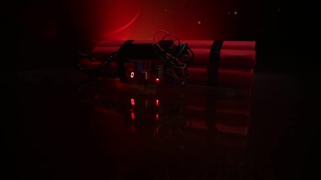 Image of a time bomb against dark background. Timer counting down to detonation illuminated in a shaft light shining through the darkness, conceptual image