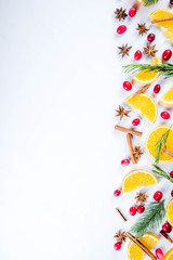 Winter autumn drink and food ingredients. Cranberries, sliced oranges, cinnamon, rosemary, anise for cooking cocktails, with christmas tree branches. Flatlay on white background. Top view copy space