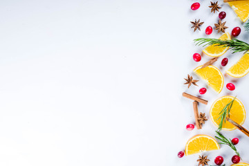Winter autumn drink and food ingredients. Cranberries, sliced oranges, cinnamon, rosemary, anise for cooking cocktails, with christmas tree branches. Flatlay on white background. Top view copy space