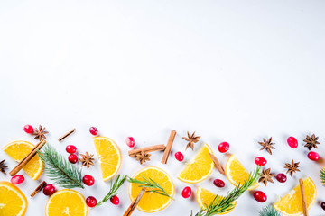 Winter autumn drink and food ingredients. Cranberries, sliced oranges, cinnamon, rosemary, anise for cooking cocktails, with christmas tree branches. Flatlay on white background. Top view copy space