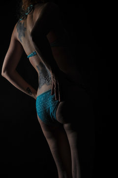 frau in t&uuml;rkisen slip mit tattoo am arschgeweih po r&uuml;cken