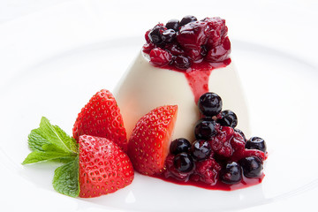 Dessert panna cotta with fresh berries on white background