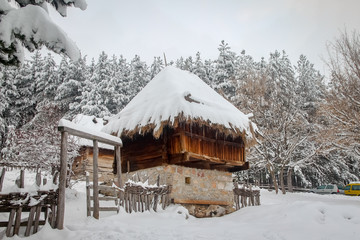 Village with old retro idyllic houses covered with snow in mountain. Village Sirogojno on mountain Zlatibor in Serbia.