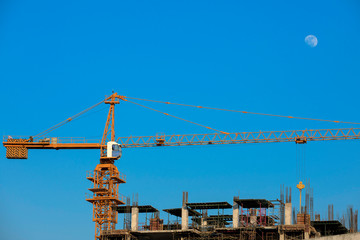 Crane and construction workers at construction sites.Sky and moon background