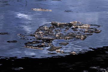 Pieces of ice in winter water at dusk