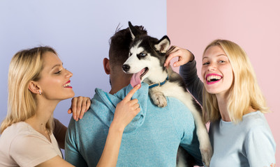 Naklejka na ściany i meble Play with your dog to help him live to his fullest. Happy family have fun with husky dog. Happy women and man play with family pet. Friends with purebred dog breed. Pet sitters care for the pet