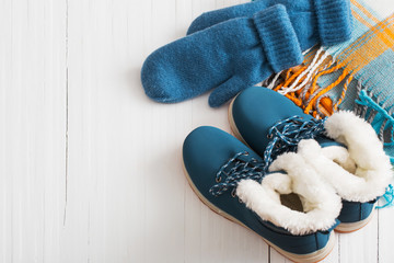 blue winter shoes and gloves on white wooden background