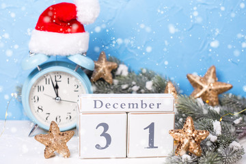 Calendar, blue alarm clock,  branches fir tree and golden stars on  blue textured  background.