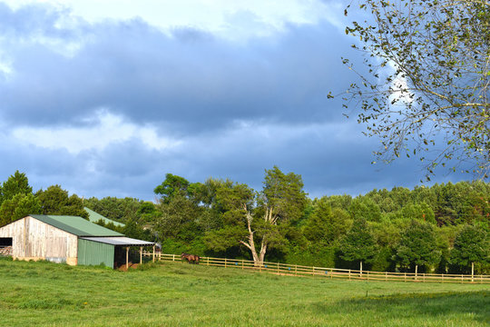storm clouds over  pasture with barn