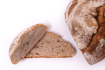 Loaf of organic farmer`s bread with slices, isolated on white background