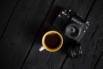 SERBIA, BELGRADE , DECEMBER 20 2018 :  Vintage Zenit camera isolated on wooden table with cup of...