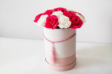 Beautiful red and white roses in a round box on a white background