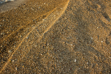 sand and small stones sea waterfront dunes waves shoreline background texture wallpaper pattern with empty space for copy or your text