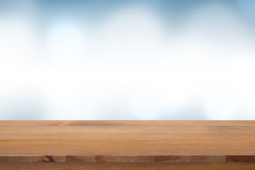 Empty of top wooden desk with blurred light blue gradient bokeh abstract background