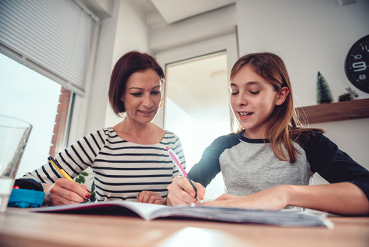 Mother helping daughter to finish homework