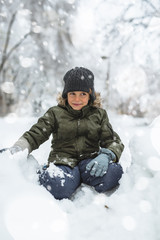 Fototapeta na wymiar cute little boy playing in snow outdoor