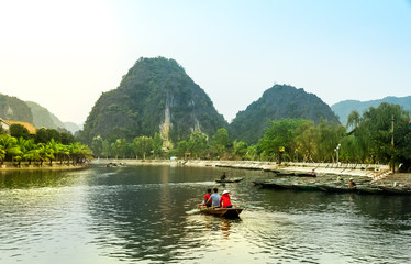 Fototapeta na wymiar Travel by boat in flooded areas submerged trees in YEN stream, Myduc, Hanoi, Vietnam.