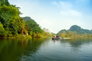 Travel by boat in flooded areas submerged trees in YEN stream, Myduc, Hanoi, Vietnam.