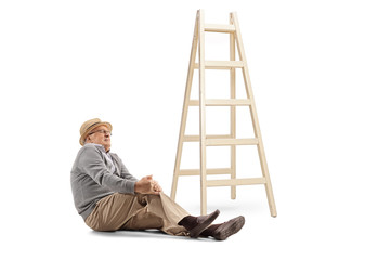 Elderly man fallen off a ladder sitting on the floor and holding his knee © Ljupco Smokovski