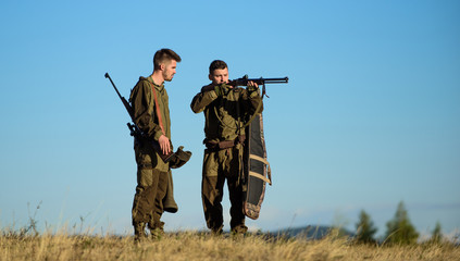 Hunters gamekeepers walk mountains background. Hunters with rifles in nature environment. Hunter...