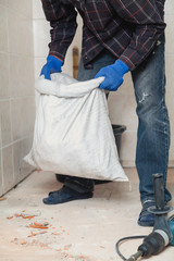 employee raises bag of garbage