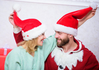 Couple in love enjoy christmas celebration. Couple wear hats as santa claus christmas tree...