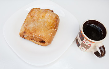 Sweet bread with guava paste filling. Served with coffee, in a white dish.