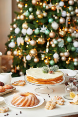 Christmas cake and sweets on table. Christmas  decorations with lights background. Happy New Year! Christmas greeting card. Winter card template. Xmas concept. Holiday Banner. Feast of Nativity. 