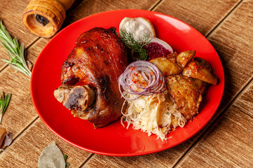 Czech cuisine concept. Baked pork knuckle, with sauerkraut, fried potatoes, with beetroot snack. Background image for recipes.