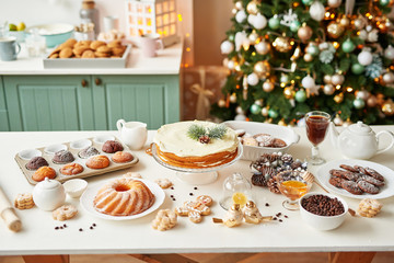 Christmas cake and sweets on table. Christmas  decorations with lights background. Happy New Year! Christmas greeting card. Winter card template. Xmas concept. Holiday Banner. Feast of Nativity. 