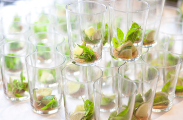 Mojito empty glasses with green leaves, sugar and lime