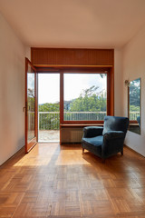 Fototapeta na wymiar Sunny room interior with window and blue velvet armchair in country house