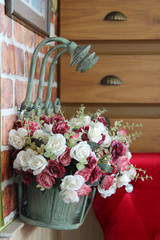 Shower head decorated on flower pot on brick wall.