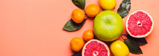 Grapefruit surrounded by lemons and mandaroins. Living coral background. Color trend 2019