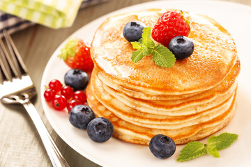 pile of pancakes with fresh berries and mint