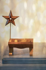 Faith based Christmas photograph of a wooden Jesus figure in a manger with a star and a starry background - obrazy, fototapety, plakaty