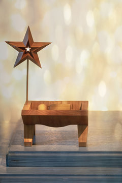 Faith based Christmas photograph of a wooden Jesus figure in a manger with a star and a starry background