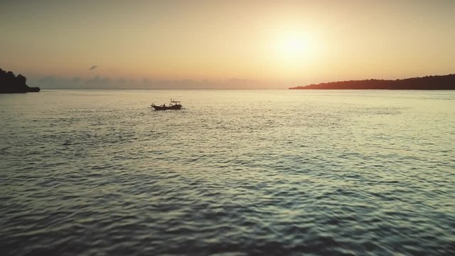 Aerial Drone Shot: Fishing Boats Silhouette in Sunset Ocean. Beautiful landscape in Tropical Bali Island, Indonesia. Travel Vacation Recreation Paradise Tourism Concept. Camera goes away 4K Zoom out
