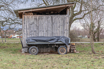 Anhänger vor einem Holzschuppen