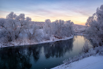 beautiful winter landscape. river with snow-covered banks in the morning at dawn