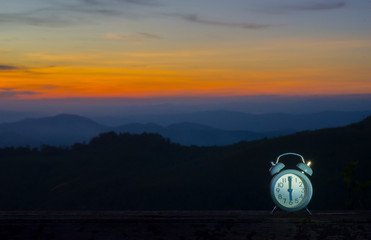 An alarm clock with a background of wild landscapes and mountain