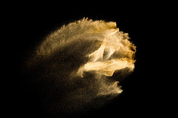 Dry river sand explosion. Golden color sand splash against  black background.