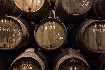 Row of wooden porto wine barrels in wine cellar Porto, Portugal.