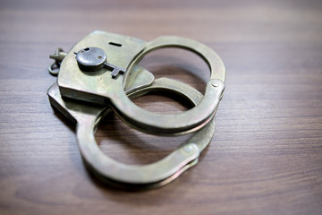 Selective focus on handcuffs on a keyboard cyber crime, hacking, bullying Against law concept in...
