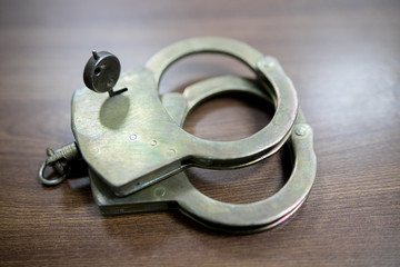 Selective focus on handcuffs on a keyboard cyber crime, hacking, bullying Against law concept in...