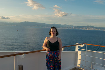 Fototapeta na wymiar Beautiful woman enjoying the sun on a deck of a cruise ship: luxury vacation