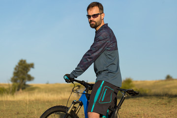 Cyclist in shorts and jersey on a modern carbon hardtail bike with an air suspension fork	