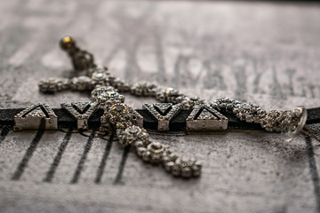 Earrings and choker, jewelry for girls. Jewelry and accessories on black and white background. Fashion and style in grey tones. Shiny stones and rhinestones on a metallic silver background.