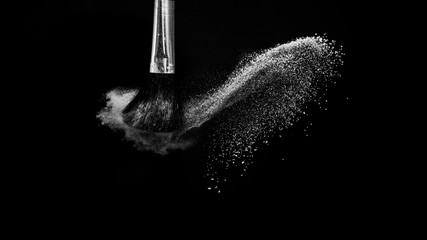Cosmetic brush with white cosmetic powder spreading for makeup artist or beauty blogger in black...